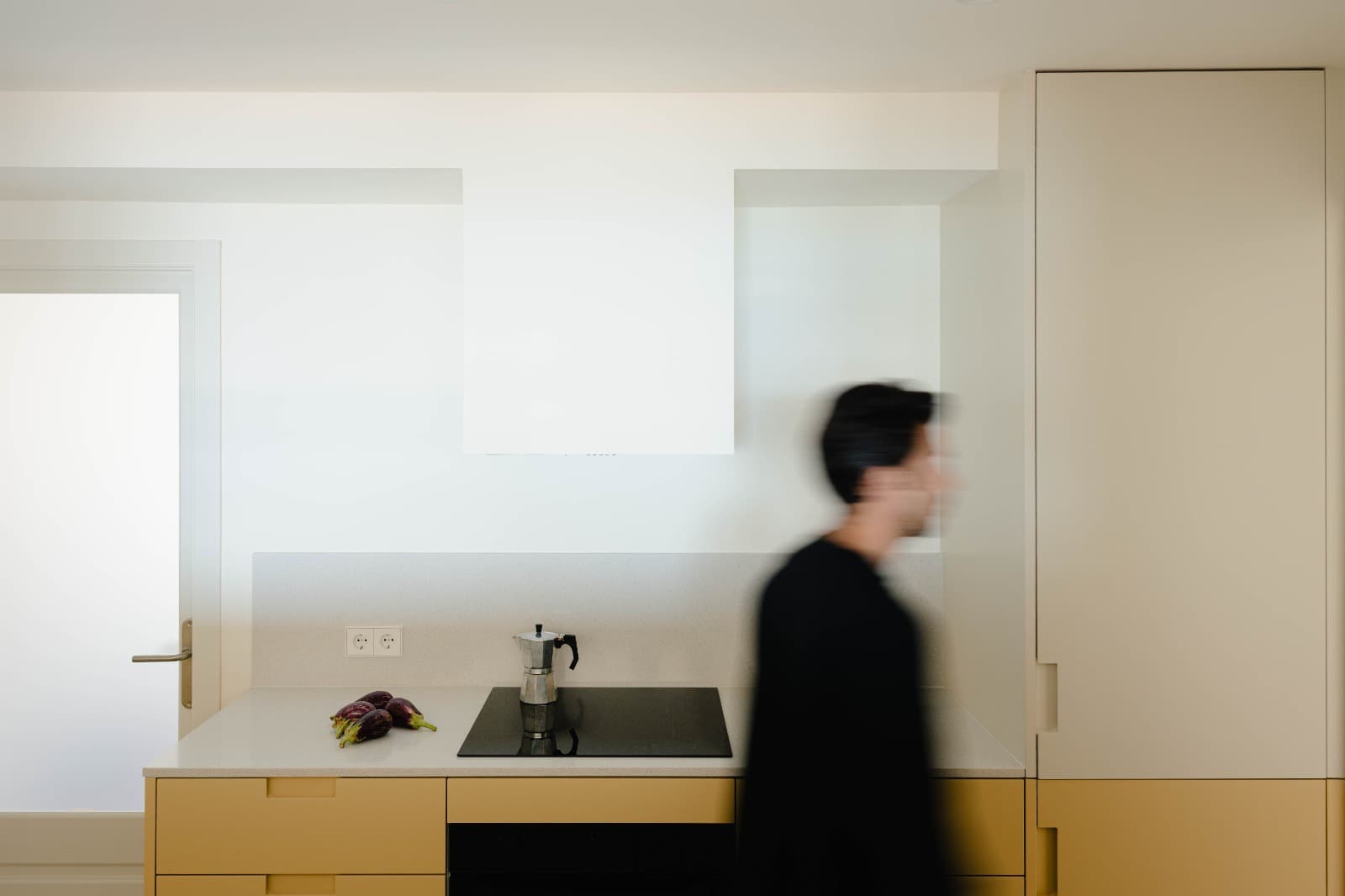 Cocina y comedor luminosos con frentes de madera y una gran ventana arqueada