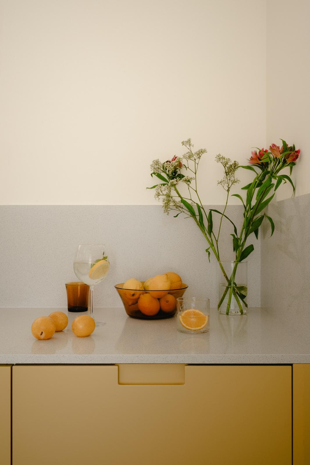 Bodegón de flores y cítricos sobre la encimera
