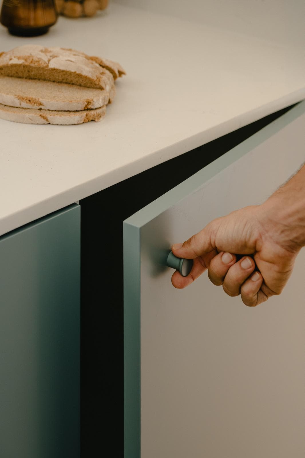 Mano abriendo uno de los frentes de la cocina Terol